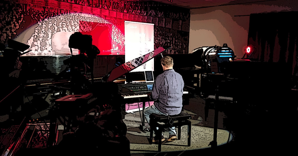 Kleine Dokumentation im Comic-Style zum Yamaha-Videodreh Digitalpiano Clavinova CVP-809 mit Susan Albers und Peter Baartmans im Musikhaus Kirstein in Schongau. Comic-Bild 25: Peter Baartmans sitzt am Digitalflügel und spielt.