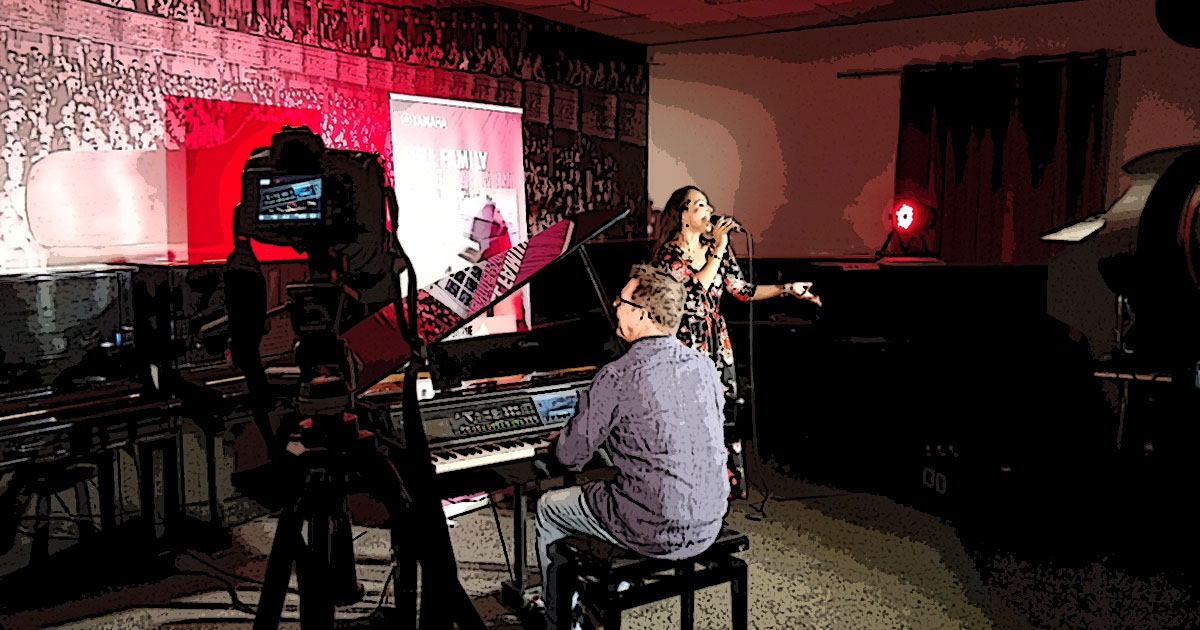 Kleine Dokumentation im Comic-Style zum Yamaha-Videodreh Digitalpiano Clavinova CVP-809 mit Susan Albers und Peter Baartmans im Musikhaus Kirstein in Schongau. Comic-Bild 28: Peter spielt Klavier, Susan singt dazu.