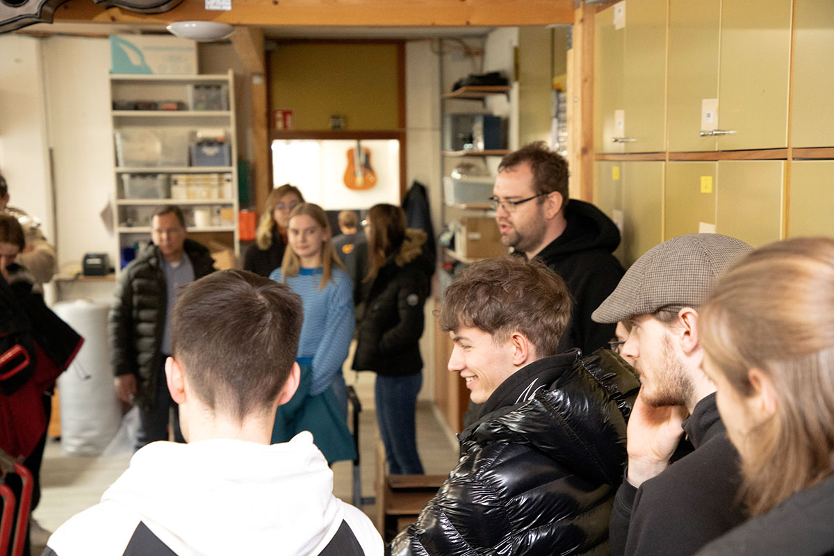 Schüler der Berufsschule Mittenwald bei Ausführungen durch Frank Gallitschke, Metallblasinstrumentenmachermeister, im Zentrallager von Musikhaus Kirstein