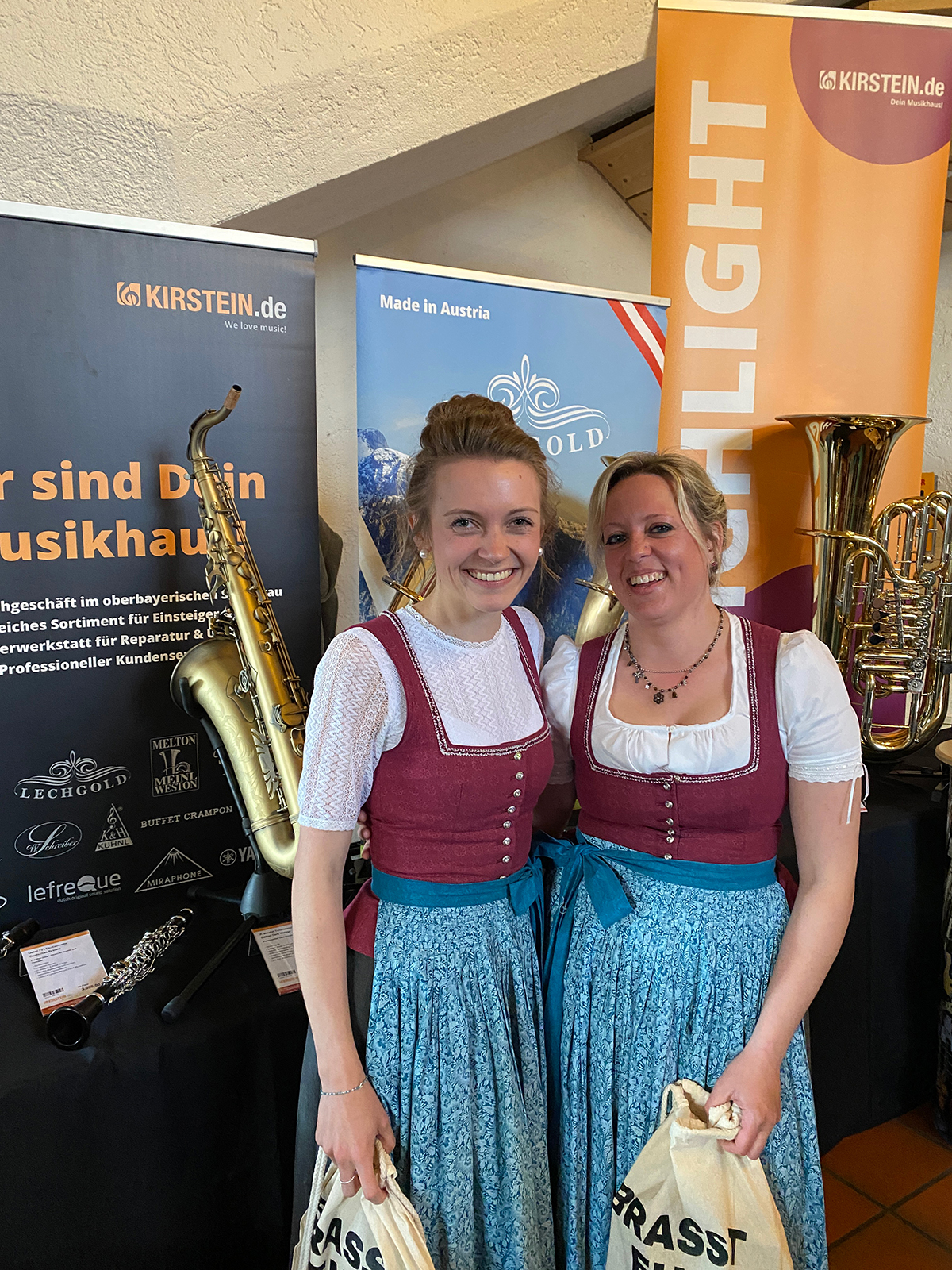 Zwei Besucherinnen in Tracht am Stand der Instrumentenausstellung von Musikhaus Kirstein beim Konzertabend in Krün