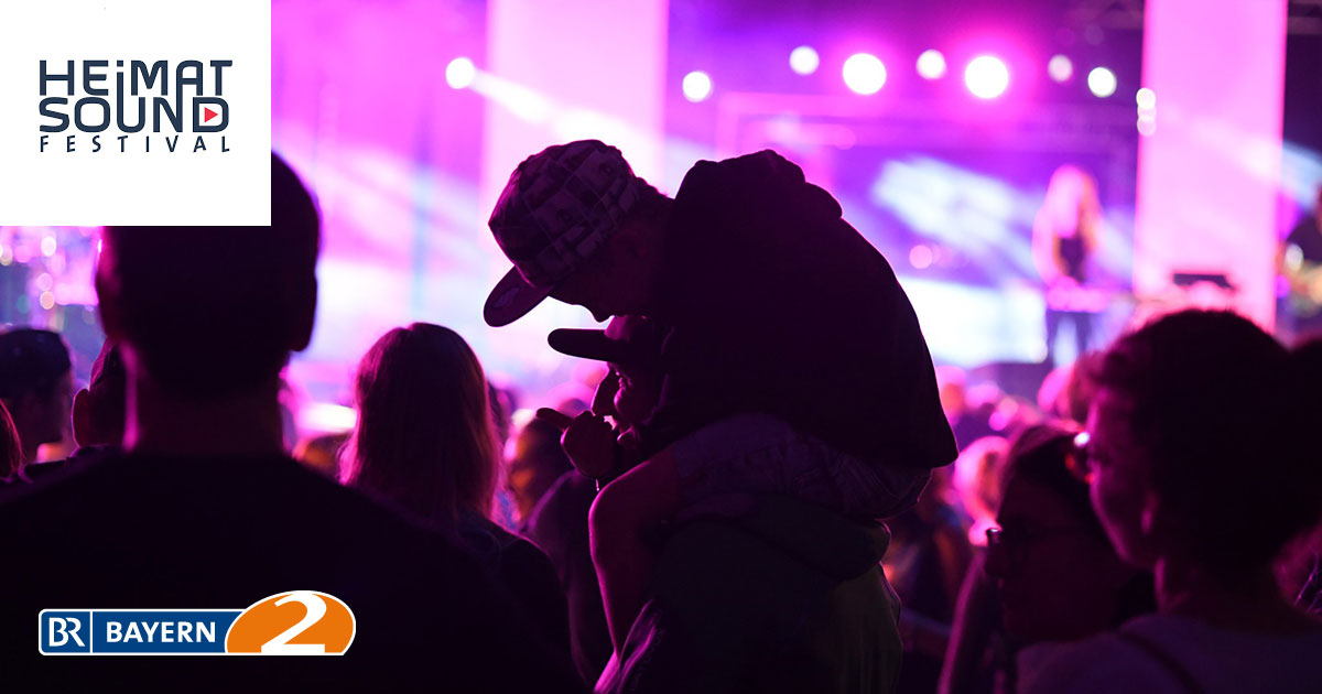 Impression vom Heimatsound-Festival 2019. Publikum mit Logo des Heimatsound-Festivals und Logo Bayern 2.