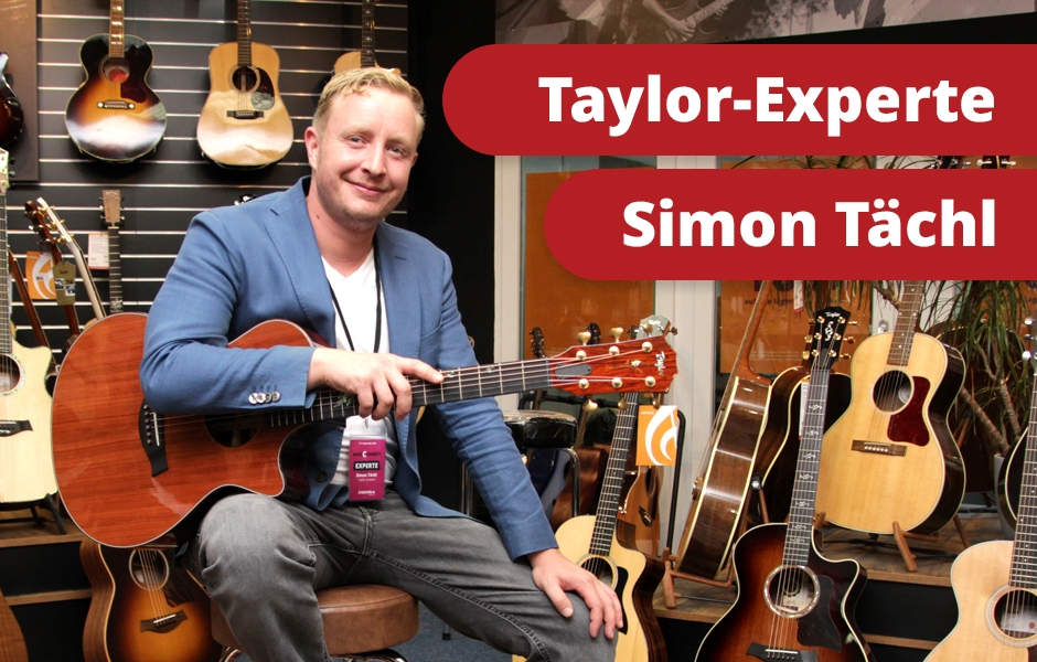 Taylor Guitars Experte Simon Tächl in der Gitarrenausstellung vom Musikhaus Kirstein zwischen vielen Westerngitarren