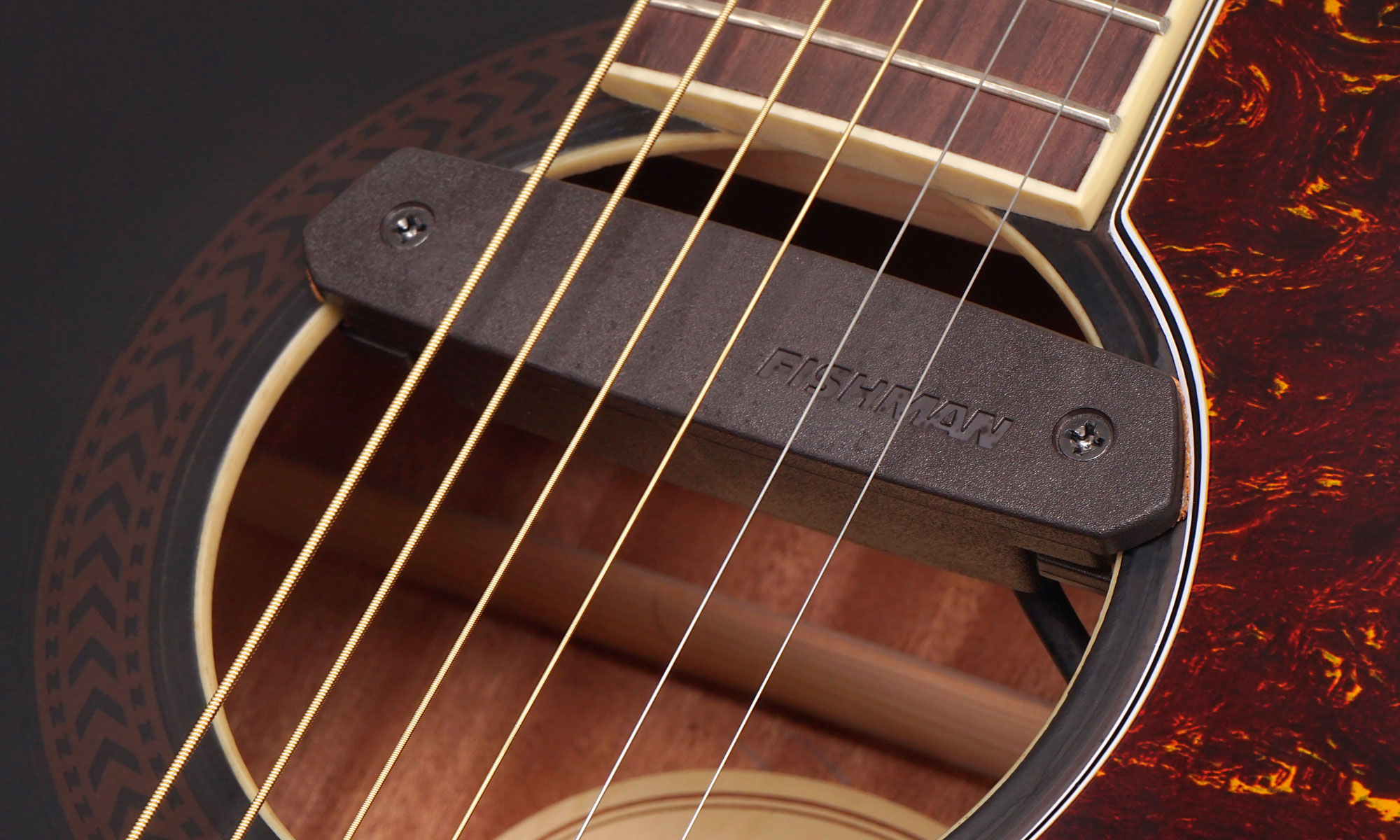 Westerngitarre mit elektromagnetischem Tonabnehmer, der am Schallloch angebracht ist.